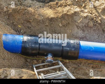 Processus de réparation de canalisation d'eau souterraine. Tubes en plastique bleu dans la tranchée soudés ensemble avec les tuyaux en plastique avec vis et co-membre de fl Banque D'Images