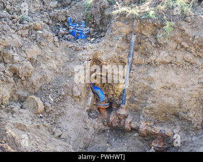 Tranchée pour la pose d'une canalisation d'approvisionnement en eau. Construction de canalisations d'eau potable avec porte en tranchée peu profonde. Banque D'Images