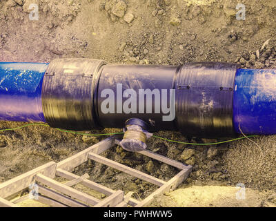 Tranchée pour la pose d'une canalisation d'approvisionnement en eau. Construction de canalisations d'eau potable avec porte en tranchée peu profonde. Banque D'Images