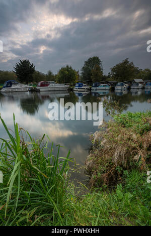 Lumière du soir l'atmosphère au-dessus de la rivière nene à Orton ou de verrouillage simple près de Peterborough avec bateaux amarrés sur la rive. Banque D'Images