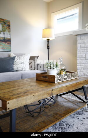 Coin salon confortable avec un tronc en rotin table basse et un canapé ivoire garni d'oreillers. Banque D'Images