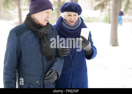 Videochatting Senior Couple in Park Banque D'Images