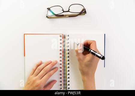 Woman's hands avec stylo écrit sur ordinateur portable. Bureau bureau moderne. Concept de travail, l'écriture Banque D'Images