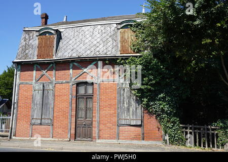 Façade en briques rouges d'une ancienne maison de campagne typiquement abandonné dans une rue d'une petite ville de France Banque D'Images