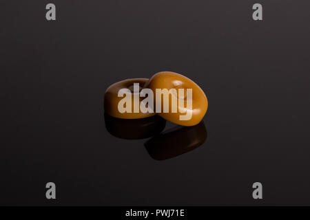 Groupe de deux ensemble crème caramel caramel bonbon variété sur verre noir Banque D'Images