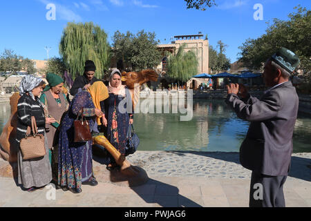 Les locaux posant à la caméra à Lyabi-Hauz ou Lyab-i Khauz une place construite autour d'une piscine considérée comme la Centre de la vieille ville de Boukhara en Ouzbékistan Banque D'Images