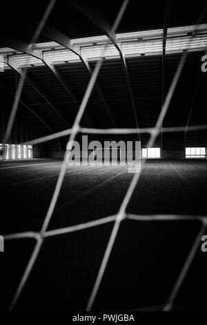 Une piscine vide football / soccer terrain d'entraînement en gazon artificiel avec des buts et des filets en Islande pendant toute l'année d'utilisation. B/W Banque D'Images