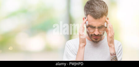 Les jeunes adultes avec la main de l'homme tatoué sur la tête pour la douleur dans la tête parce que le stress. Souffrant de migraines. Banque D'Images