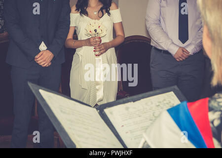 La lecture d'enregistrement de mariage contrat de mariage au bureau de l'état civil. Selective focus sur les mariés. Banque D'Images