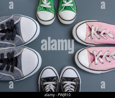 Quatre paires de vieilles chaussures textile sur un fond noir, femmes, les hommes et les chaussures pour enfants, copy space Banque D'Images