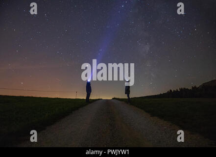 Un homme avec une lampe à uptsairs au ciel de la nuit et de Voie lactée. Banque D'Images