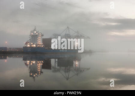 Tivoli, Cork, Irlande. 17 octobre, 2018. Tôt le matin, le brouillard descend sur le port comme le cargo BG Jade est chargé avec des conteneurs au Tivoli Docks, Cork, Irlande. Crédit : David Creedon/Alamy Live News Banque D'Images