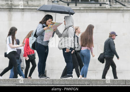 London UK. 17 octobre 2018. Les piétons à l'abri de la pluie Bruine à Trafalgar Square Londres sur un ovecast humide jour Crédit : amer ghazzal/Alamy Live News Banque D'Images