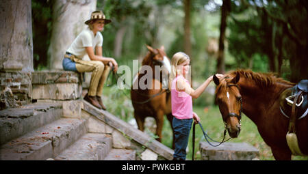 Teenage Girl standing with her young mère et deux chevaux. Banque D'Images