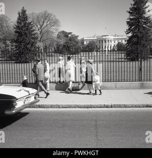 Années 1950, historiques, de la mère avec ses enfants, dont deux sont d'escalade sur le périmètre des garde-corps pour avoir une vue de la Maison Blanche, l'accueil du président américain, Washington DC, USA. Banque D'Images