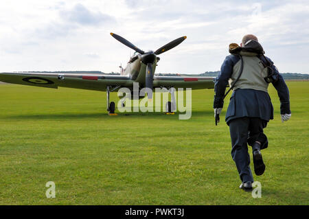 Bataille d'Angleterre bousculant la recréation. RAF, le réacteur pilote de la Royal Air Force de la Seconde Guerre mondiale court vers l'avion de chasse Hawker Hurricane Banque D'Images