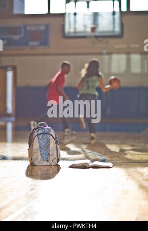 Teenage boy and girl playing basketball Banque D'Images