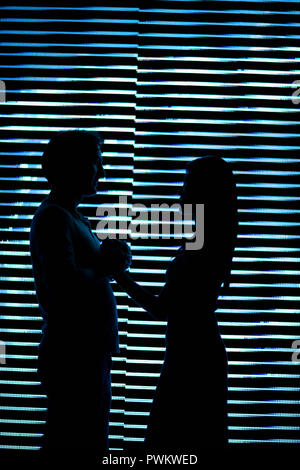 Silhouette d'un couple en face de l'autre. Banque D'Images