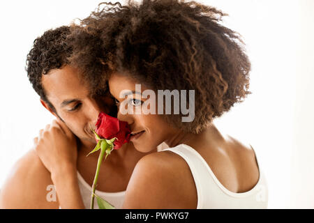 Jeune femme qui sent la rose de son petit ami. Banque D'Images