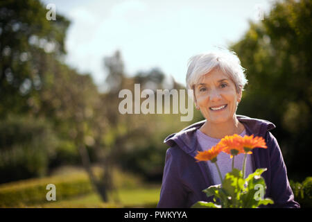 Portrait of a senior woman smiling dans son jardin. Banque D'Images