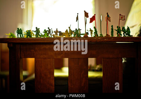 Petits soldats organisés en formation sur une table dans une chambre à coucher. Banque D'Images