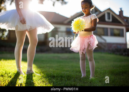 Jeune fille jouant avec sa mère dans leur cour arrière. Banque D'Images