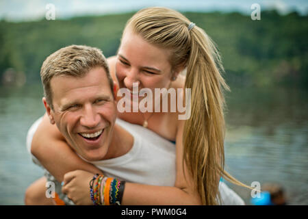 Smiling middle aged homme donnant à sa fille un piggyback ride. Banque D'Images