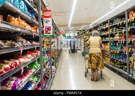 En poussant vers le bas Shoppers trolleys une allée au supermarché Woolworths,Tamworth NSW Australie. Banque D'Images