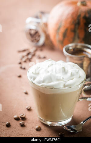 Latte de citrouille avec crème fouettée et d'épices, avec des citrouilles sur fond brun. Banque D'Images