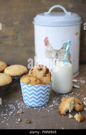 Cookies aux pépites de chocolat avec noix de coco et une bouteille de lait Banque D'Images