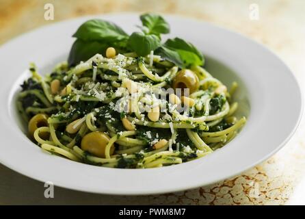 Spaghetti au pesto d'épinards et d'olives vertes Banque D'Images
