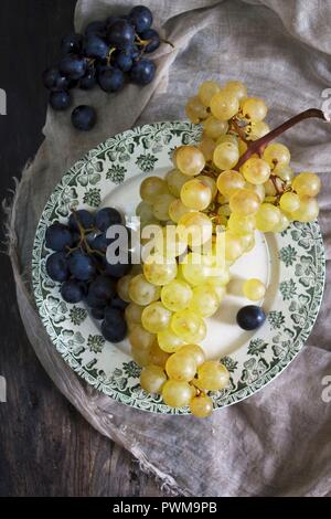 Raisin violet et vert sur une assiette (vu du dessus) Banque D'Images