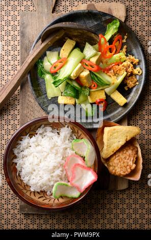 Sawi Tumis Hijau (Indonesian sauté de bok choy) servi le riz blanc, le tempeh et le tofu Banque D'Images