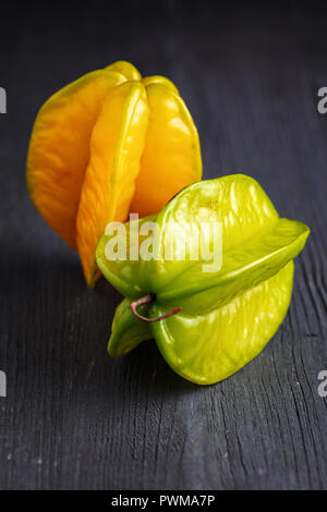 Venu de jaune et de vert carambole carambole ou étoile ( apple ) caramboles sur fond de bois foncé Banque D'Images