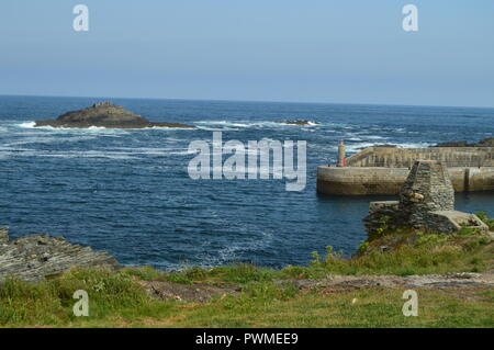 Bay avec les vagues se brisant sur ses Rochers en arrière-plan une petite île et l'entrée du port à Tapia de Casariego. Nature, Voyage, Recreati Banque D'Images