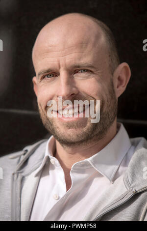 Portrait of a handsome smiling man avec une légère barbe et cheveux rasés. Banque D'Images