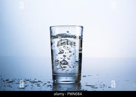 On verse de l'eau dans un verre. Banque D'Images