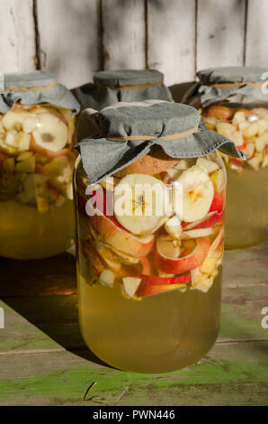 Fabrication de vinaigre de pomme - morceaux de pomme flottant sur l'eau dans un verre Banque D'Images