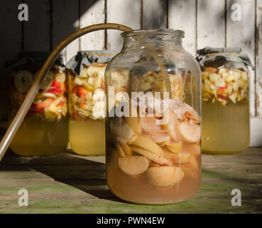 Fabrication de vinaigre de pomme - morceaux de pomme flottant sur l'eau dans un verre Banque D'Images