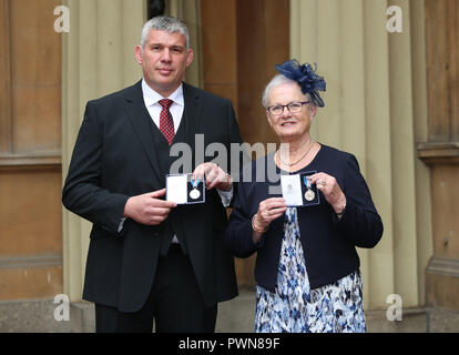 La CORRECTION DE LA FIN DE LÉGENDE RETRANSMIS À LA FIN DE SON MARI Stephen Adams et Margaret Guest holding Médailles de Bravoure Queen's après une cérémonie au Palais de Buckingham, à Londres. Banque D'Images