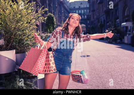 Shopaholic élégant l'attelage d'une ride après toute une journée de shopping dans les boutiques de fantaisie Banque D'Images