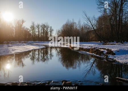 Paysage avec le soleil qui brillait à travers les arbres sur une rivière, nouvellement décongelé reflétant les arbres et ciel bleu. Mongolie, arkhangaï Banque D'Images