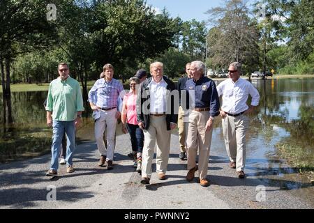 Président américain Donald Trump, centre, promenades avec Caroline du Sud Gouverneur Henry McMaster, droit, lors d'une visite pour voir les inondations causées par l'ouragan Florence le 19 septembre 2018 à Conway, Caroline du Sud. Florence l'objet de dumping des quantités record de précipitations le long de la côte de la Caroline du Nord et du Sud l'origine d'inondations. Banque D'Images