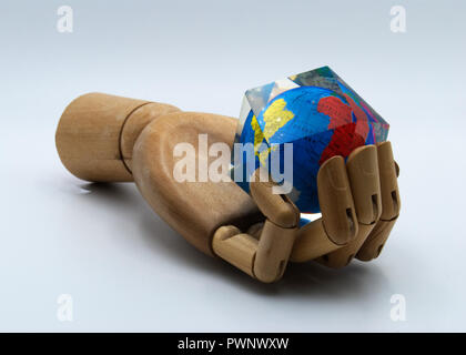 Une main en bois holding Earth