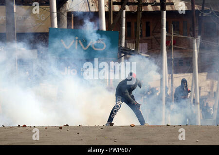 Srinagar, Jammu-et-Cachemire, en Inde. 17 Oct, 2018. Un manifestant réagit après la police indienne a tiré des gaz lacrymogènes près du site de canister gunbattle de Srinagar, la capitale d'été du Cachemire sous contrôle indien le 17 octobre 2018. Manifestations Anti-violents et des affrontements ont éclaté dans de nombreuses régions de Srinagar après un gunbattle entre rebelles et forces de sécurité indiennes ont fait rage dans la partie ancienne de la ville de Srinagar dans laquelle deux rebelles, un civil qui prétend être la police de rebelles et un policier du groupe d'opérations spéciales (GOS) ont été tués. Credit : Faisal Khan/ZUMA/Alamy Fil Live News Banque D'Images