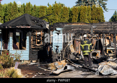 Springfield, Oregon, United States. 17 octobre, 2018. Le chef des pompiers, Ennis évalue les dommages causés à une maison après un inconnu s'allume plusieurs maisons, puis tire sur les premiers intervenants avant de prendre sa propre vie. Joshua Rainey/Alamy Live News Banque D'Images