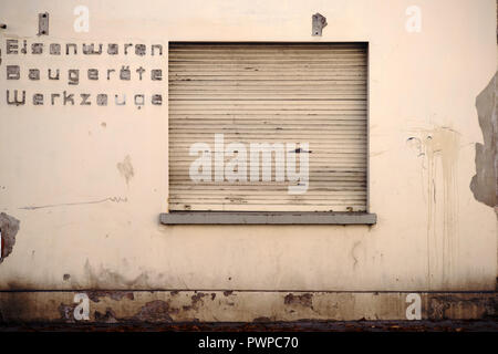 La façade d'une jaunies quincaillerie fermée avec volets abaissés. Banque D'Images