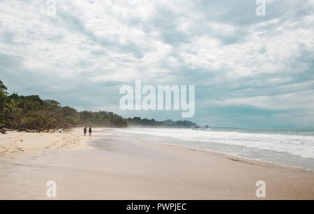 Deux voyageurs randonnée marche sur la grande plage de sable blanc de Red Frog Beach, une île des Caraïbes au large de Panama Banque D'Images