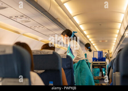 BANGKOK, THAÏLANDE - Sep 27, 2018 - Bangkok Airways flight attendant servent de la nourriture et des boissons aux passagers à bord. Banque D'Images