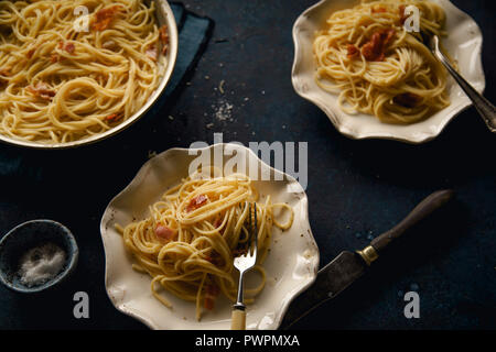 Les pâtes italiennes carbonara avec du bacon sur fond sombre Banque D'Images